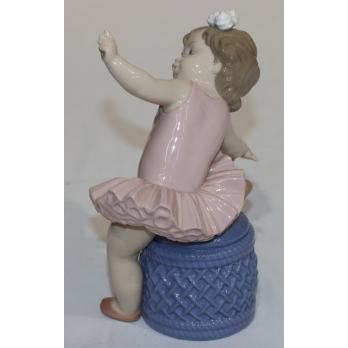 98 - A Lladro figure of a young ballerina child seated on a pouffe, 16.5cm high