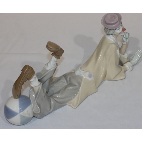 110 - A Lladro group of a resting clown with his foot on a ball, 37cm long, 16cm high