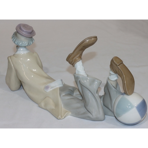 110 - A Lladro group of a resting clown with his foot on a ball, 37cm long, 16cm high