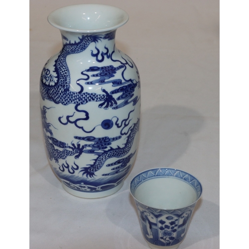 115 - An Oriental blue and white round bulbous trumpet shaped vase with dragon decoration, 21.5cm and an O... 