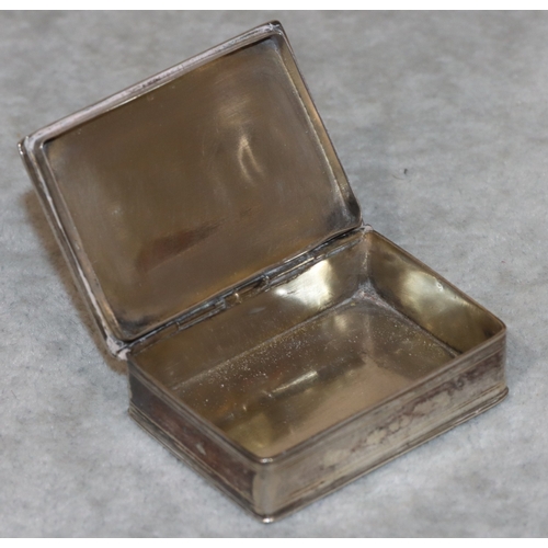 187 - A Continental silver coloured metal rectangular shaped snuff box with hinged lid and embossed figure... 