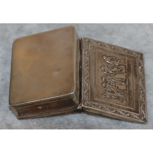 187 - A Continental silver coloured metal rectangular shaped snuff box with hinged lid and embossed figure... 