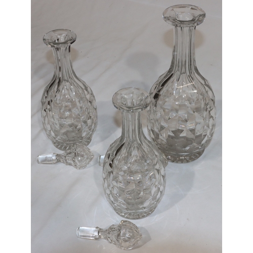 20 - A set of 3 heavy cut glass round bulbous thin necked decanters with stoppers, comprising of a pair, ... 