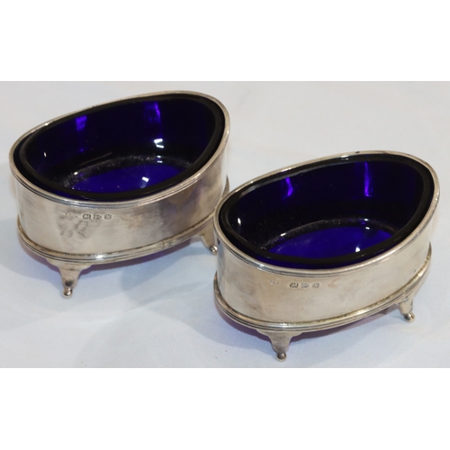 211 - A pair of Chester oval silver salts with blue glass liners, on 4 splayed feet, 8cm wide, 4.4oz