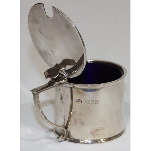 212 - An Edward VII silver round mustard pot with hinged lid enclosing blue glass liner, London 1903, make... 