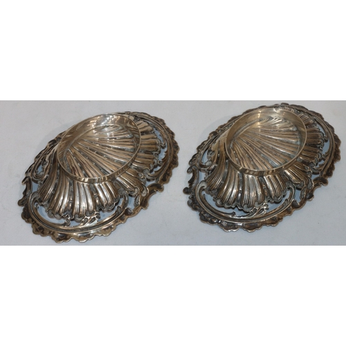 242 - A pair of Continental 800 silver coloured oval shell shaped sweetmeat dishes with embossed and pierc... 