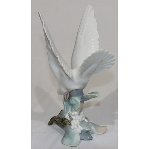 25 - A Lladro figure of a white bird perched on branch, 28cm high