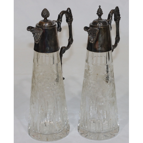 257 - A pair of modern cut glass claret jugs with silver necks, hinged lids, scroll handles and mask head ... 