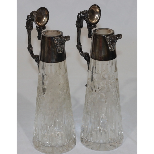 257 - A pair of modern cut glass claret jugs with silver necks, hinged lids, scroll handles and mask head ... 