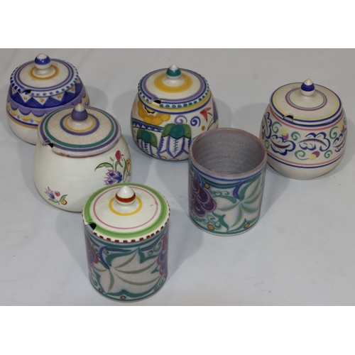 43 - A Poole Potter cylindrical jam pot with cover and multi-coloured fruit and leaf decoration, another ... 