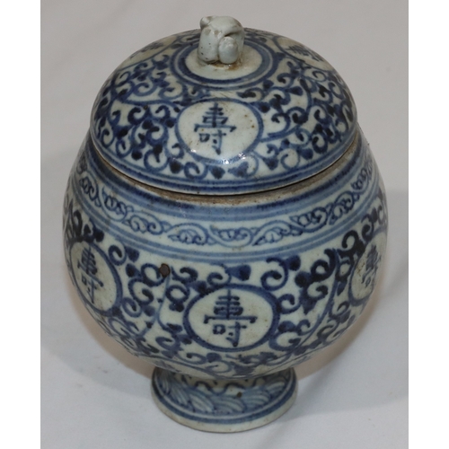 47 - An Oriental round bulbous lidded pot on blue and white ground with allover scroll and inscription de... 