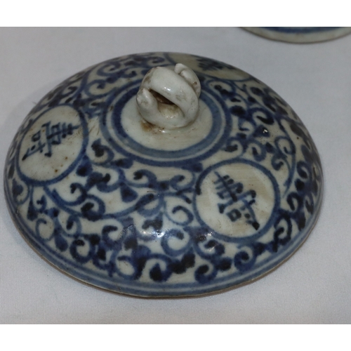 47 - An Oriental round bulbous lidded pot on blue and white ground with allover scroll and inscription de... 