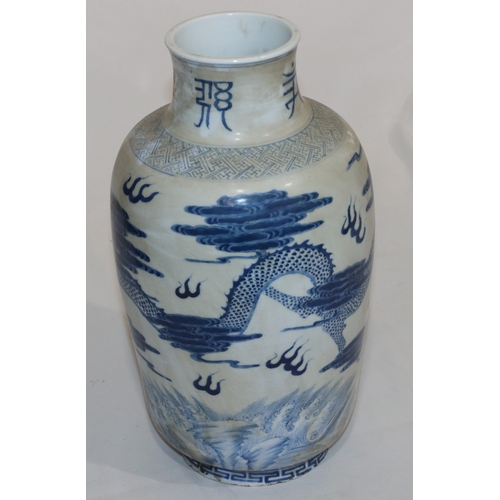 50 - An Oriental round bulbous thin necked vase on blue and white ground with dragon, cloud and inscripti... 