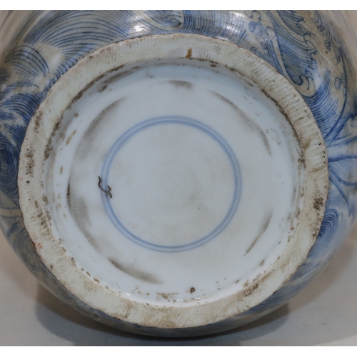 50 - An Oriental round bulbous thin necked vase on blue and white ground with dragon, cloud and inscripti... 