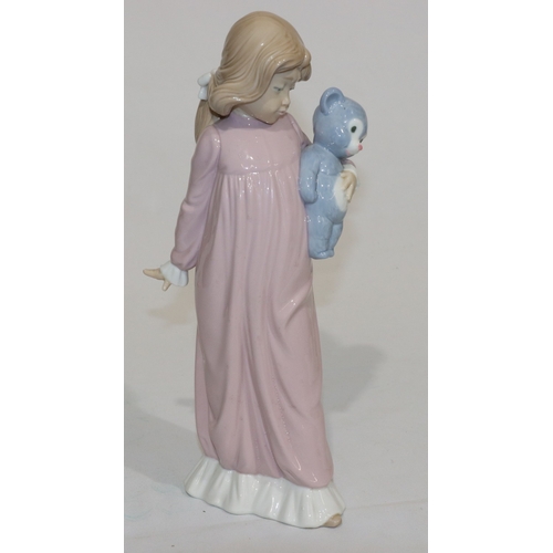 66 - A Nao figure of a young standing girl in pink nightdress holding a teddy bear, 31.5cm high