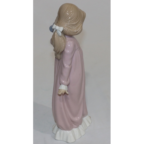 66 - A Nao figure of a young standing girl in pink nightdress holding a teddy bear, 31.5cm high