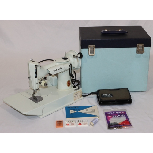 725 - A Singer Featherweight sewing machine, Model 221, on white ground, in pale blue case