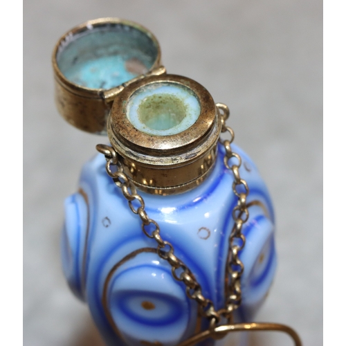 735 - An Opaline and blue pentagon shaped bulbous scent bottle with gilt metal neck and hinged lid, with c... 