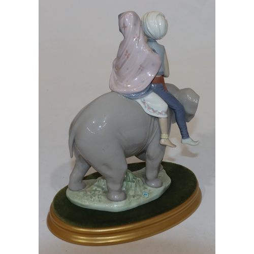 90 - A Lladro group of 2 Eastern figures seated upon elephant with oval gilt base, 23cm high without base