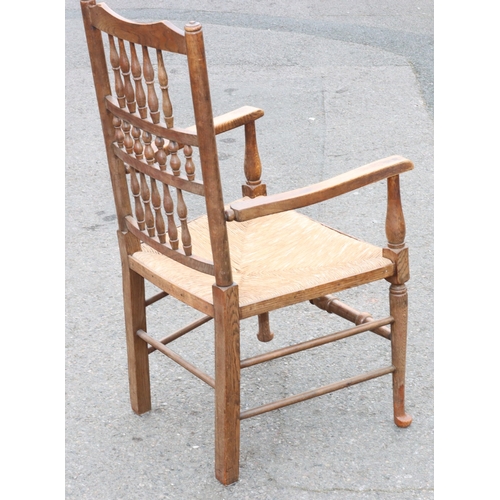 922 - An oak spindle back armchair with rush seat and turned stretchers