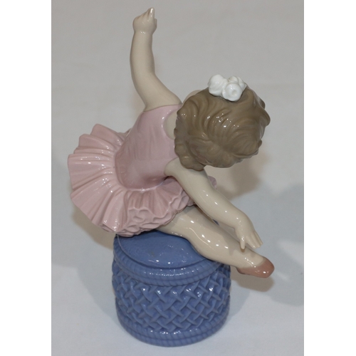 98 - A Lladro figure of a young ballerina child seated on a pouffe, 16.5cm high