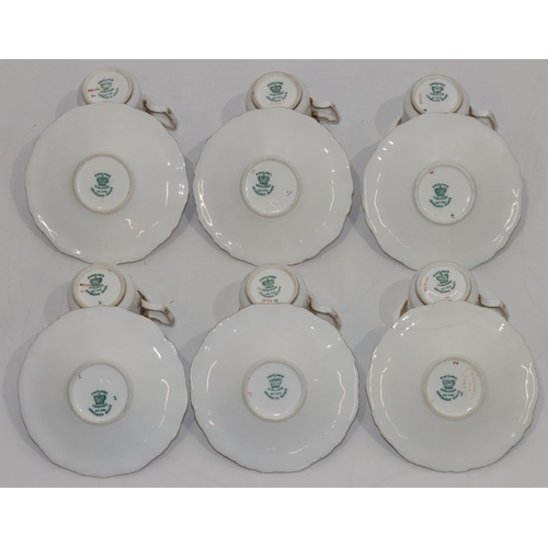 124 - A set of 6 Coalport cups and saucers on white and blue ground with multi-coloured floral, leaf and g... 