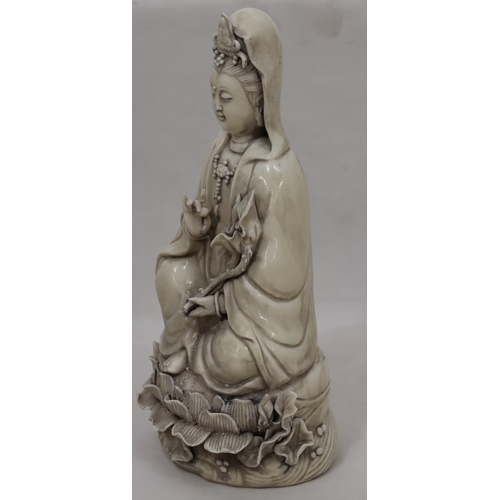 47 - An Oriental Blanc-de-Chine figure of seated Goddess holding a lotus leaf, 26.5cm high