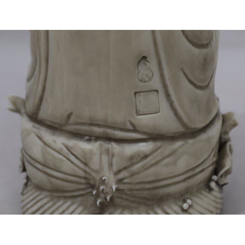 47 - An Oriental Blanc-de-Chine figure of seated Goddess holding a lotus leaf, 26.5cm high