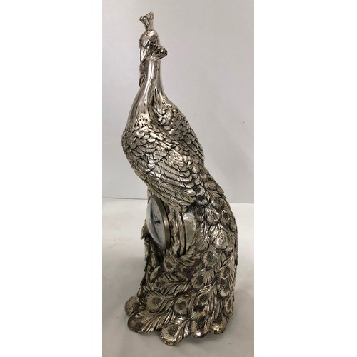 6056 - A heavy silver-coloured ornate clock in the form of 2 peacocks with central Quartz battery operated ... 