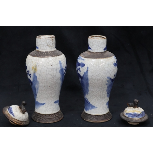 77 - A pair of Oriental blue and white round bulbous thin necked lidded vases with figure and landscape d... 