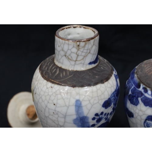 77 - A pair of Oriental blue and white round bulbous thin necked lidded vases with figure and landscape d... 
