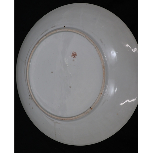 79 - An Oriental large round charger on white ground with multi-coloured figure, bridge, bird, floral, le... 