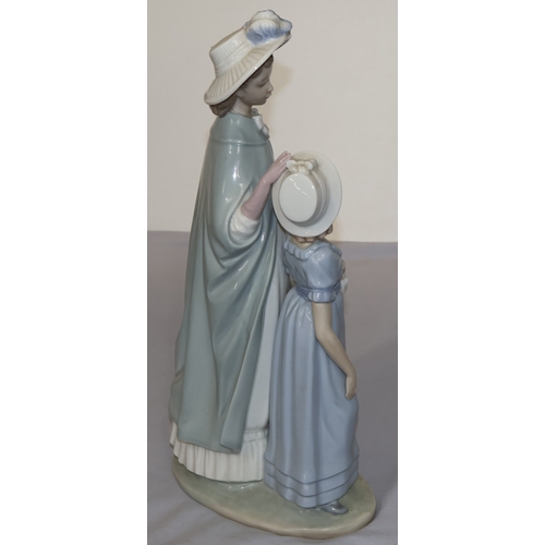 61 - A Nao group of standing lady and daughter on oval base, 38cm high