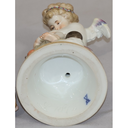 74 - A Meissen porcelain figure of a seated winged cupid pressing 2 hearts together, on round sweeping ba... 