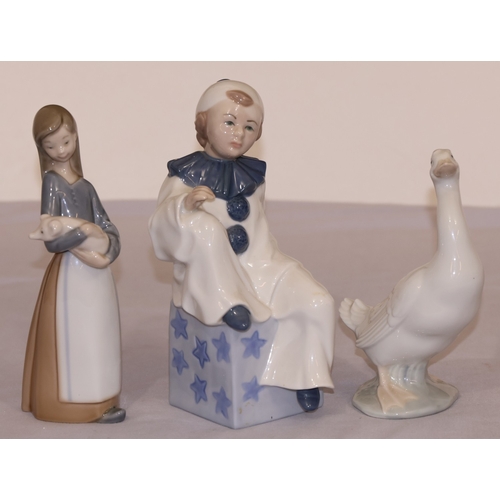 77 - A Lladro figure of a young girl holding a pig, 17.5cm high, a Nao figure of a bird and a Continental... 