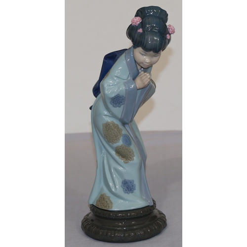 79 - A Lladro figure of a standing Oriental lady with encrusted flowers in her hair, 26cm high