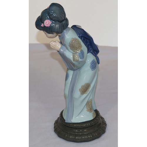 79 - A Lladro figure of a standing Oriental lady with encrusted flowers in her hair, 26cm high