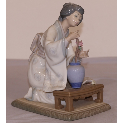 81 - A Lladro figure of a kneeling lady arranging flowers, 19cm high