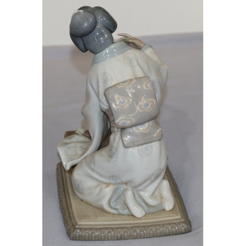 81 - A Lladro figure of a kneeling lady arranging flowers, 19cm high