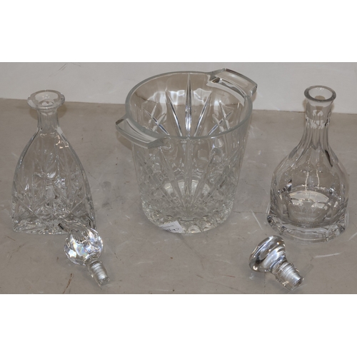 91 - A heavy cut glass round 2-handled ice bucket, 20cm high (slight chip to base) and 2 cut glass decant... 
