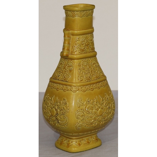 94 - A Chinese yellow rectangular bulbous thin necked vase with raised leaf and scroll decoration, 28cm h... 