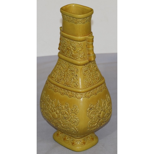 94 - A Chinese yellow rectangular bulbous thin necked vase with raised leaf and scroll decoration, 28cm h... 