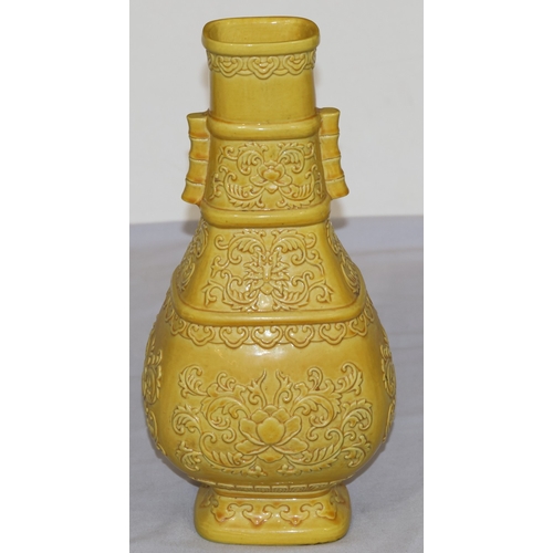 94 - A Chinese yellow rectangular bulbous thin necked vase with raised leaf and scroll decoration, 28cm h... 