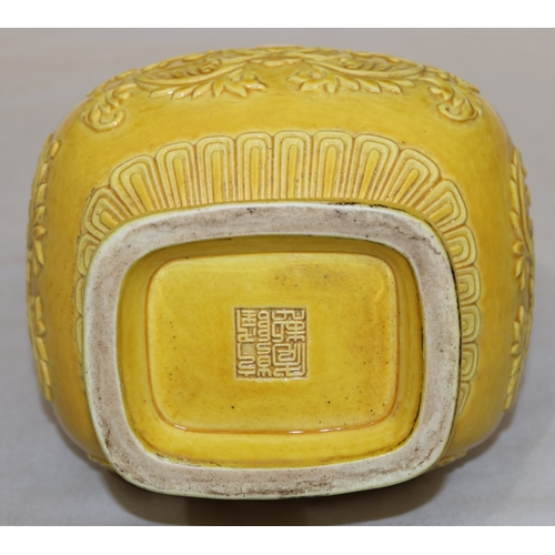 94 - A Chinese yellow rectangular bulbous thin necked vase with raised leaf and scroll decoration, 28cm h... 