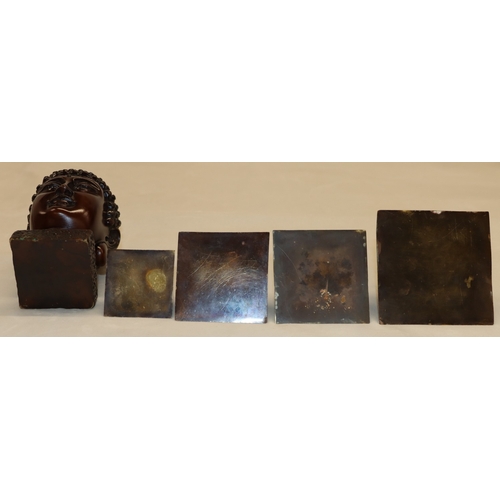 3006 - A composition Buddha head, 15.56cm high and 4 graduated composition pyramids, tallest 9cm high. (5)