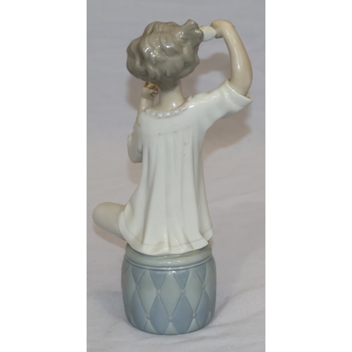 37 - A Lladro figure of a seated young girl brushing her hair (hand mirror missing), 21cm high