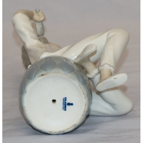 37 - A Lladro figure of a seated young girl brushing her hair (hand mirror missing), 21cm high