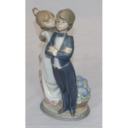 44 - A Lladro group of a young girl kissing a boy (1 finger a/f), 20.5cm high