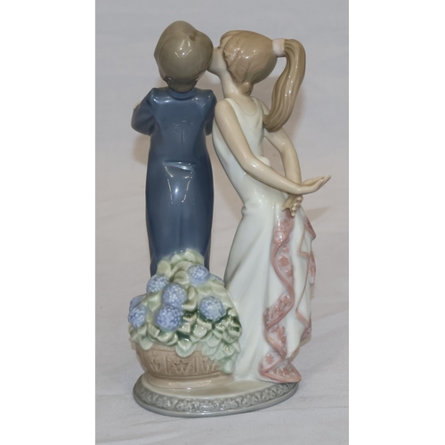 44 - A Lladro group of a young girl kissing a boy (1 finger a/f), 20.5cm high