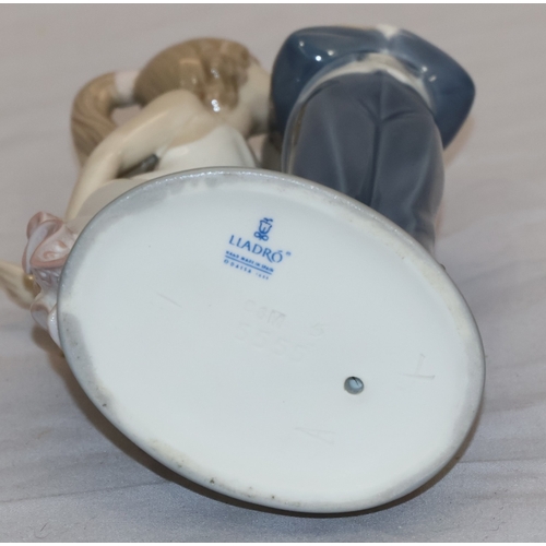 44 - A Lladro group of a young girl kissing a boy (1 finger a/f), 20.5cm high